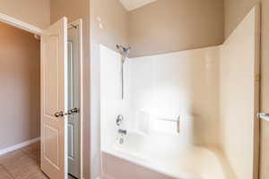 Bathroom featuring light tile patterned floors and shower / bath combination