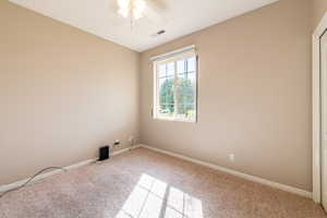 Unfurnished room featuring a ceiling fan and carpet floors