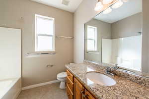 Full bath featuring vanity, light tile patterned floors, and bathtub / shower combination