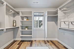 Walk in closet with light wood-style floors