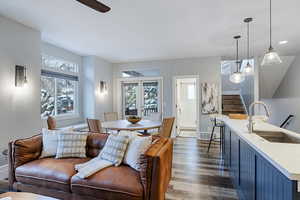 Living area with dark wood-type flooring, plenty of natural light, and a ceiling fan