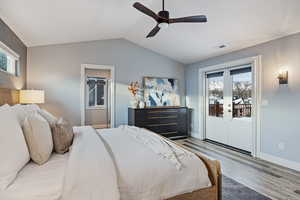 Bedroom featuring multiple windows, french doors, access to exterior, and wood finished floors