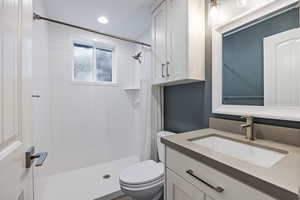 Full bath with vanity, a shower stall, and recessed lighting