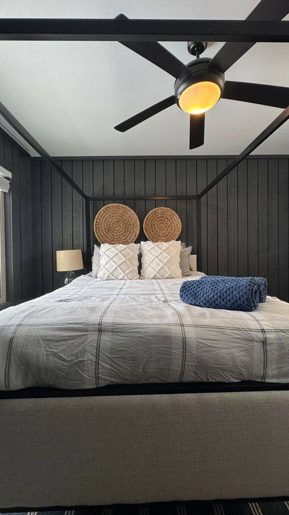 Bedroom with wood walls and ceiling fan
