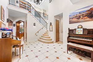 Stairway with a high ceiling, arched walkways, and tile patterned flooring