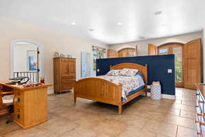 Bedroom with access to outside, recessed lighting, and arched walkways