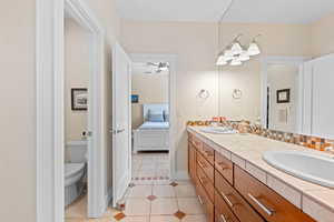 Ensuite bathroom featuring light tile patterned flooring and double vanity