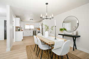 Dining space with light wood-style floors and suspended lighting