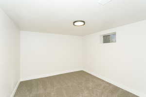 Carpeted empty room featuring baseboards
