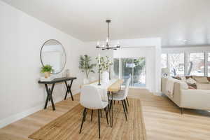Dining space with hanging lights, light wood-style floors, and a textured ceiling