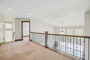 Hallway with recessed lighting, carpet floors, and vaulted ceiling