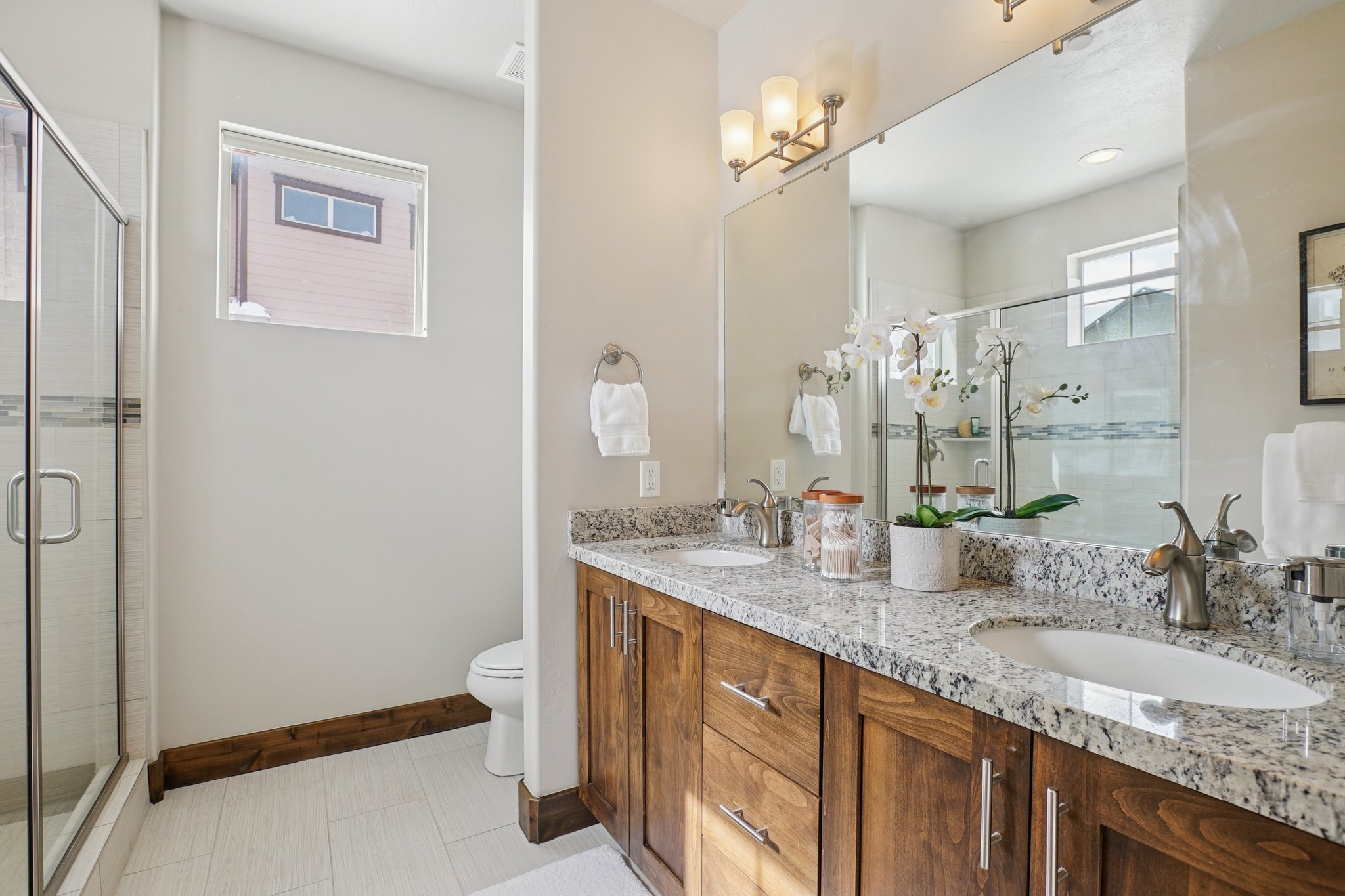 Full bath with double vanity and a stall shower