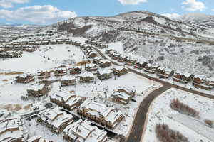 Snowy aerial view featuring a residential view and a mountain view