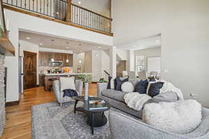 Living room featuring light wood-style floors, recessed lighting, and a high ceiling