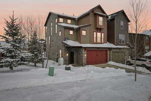 Traditional-style house with stone siding and an attached garage