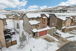 Snowy aerial view with a mountain view and a residential view