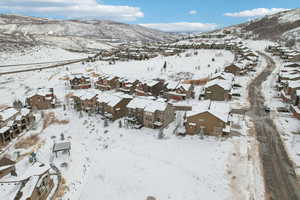Snowy aerial view featuring a mountain view and a residential view