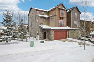 Traditional-style home with stone siding and a garage