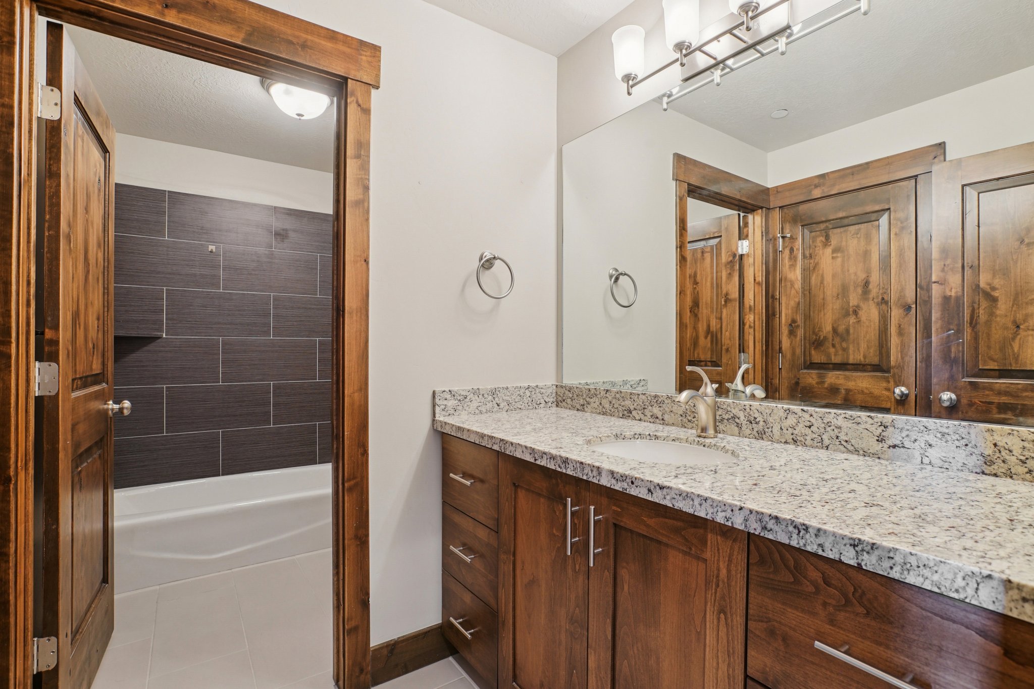 Bathroom featuring vanity, light tile patterned flooring, and shower / washtub combination