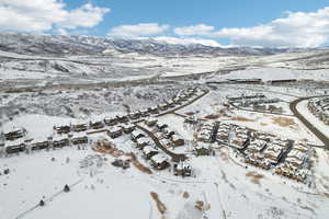Snowy aerial view featuring a mountain view and a residential view
