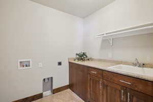 Laundry area featuring washer hookup, electric dryer hookup, and light tile patterned flooring
