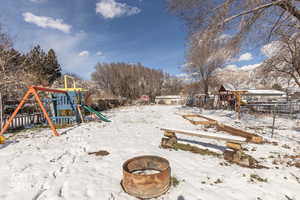 Yard layered in snow with a playground