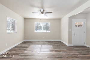 Foyer with dark wood-style floors, ceiling fan, and a textured ceiling
