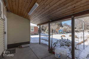 Snow covered patio featuring a playground