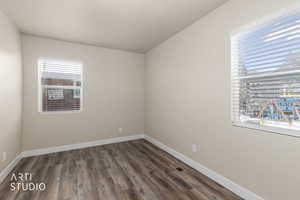 Empty room with dark wood finished floors and baseboards
