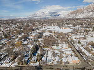 Snowy aerial view featuring a mountain view and a residential view