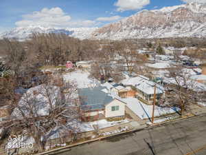 Snowy aerial view with a mountain view and a residential view