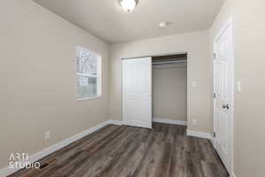 Unfurnished bedroom with dark wood finished floors and a closet