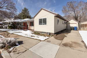 View of front of home with a garage, an outbuilding, and driveway