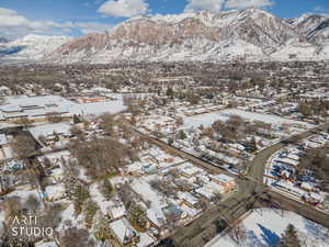 Snowy aerial view with a mountain view and a residential view