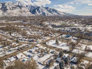 Snowy aerial view featuring a mountain view and a residential view