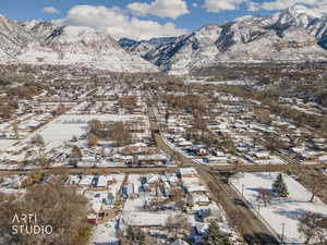Snowy aerial view featuring a mountain view and a residential view