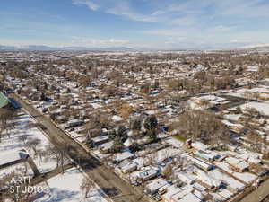 Snowy aerial view featuring a residential view and a mountain view