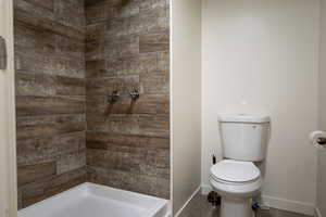 Full bathroom with toilet and a stall shower