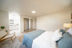 Bedroom featuring wood finished floors, ensuite bath, and wood walls