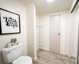 Bathroom featuring light wood finished floors and toilet