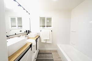 Bathroom featuring double vanity and light wood finished floors