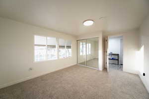 Unfurnished bedroom featuring carpet and a closet