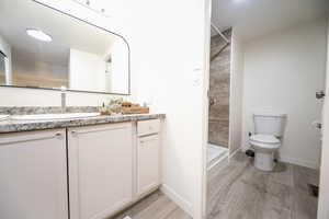 Bathroom featuring vanity, a stall shower, and light wood-type flooring