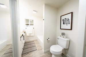 Bathroom with a garden tub, vanity, and light wood finished floors