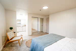Bedroom with a closet, ensuite bathroom, and wood finished floors