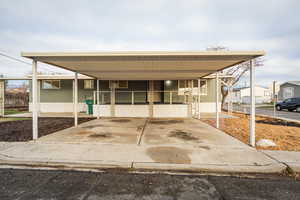 View of front of house featuring an attached carport and a porch