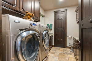 Laundry area featuring stone tile floors and separate washer and dryer