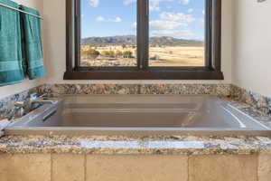 Full bath with a bath and a mountain view