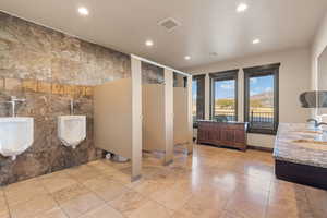Bathroom with tile walls, double vanity, a mountain view, and recessed lighting