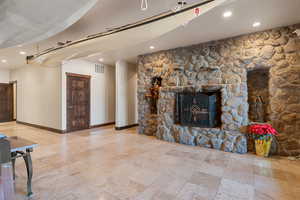 Unfurnished living room featuring recessed lighting and a stone fireplace